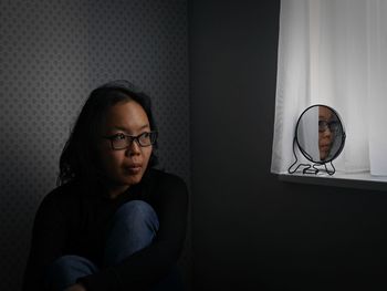 Portrait of young woman sitting at home