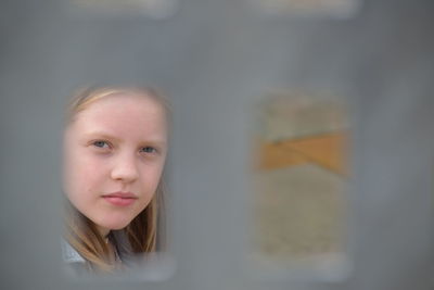 Portrait of girl seen through fence