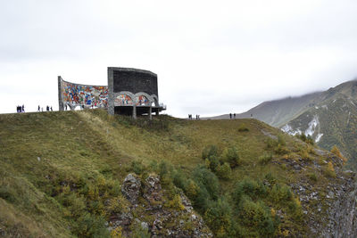 Building by mountain against sky