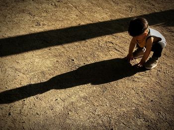 High angle view of baby boy crouching on field