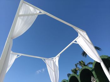 Low angle view of flags against clear blue sky