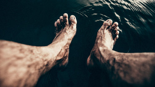 Low section of man relaxing in water