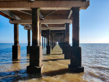 Wooden pier on sea against sky
