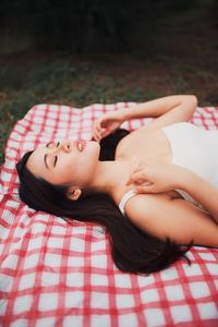 Young woman sleeping on picnic blanket