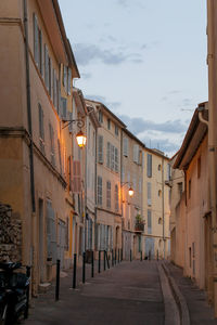 Narrow street amidst buildings against sky in city