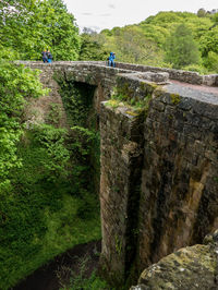 View of stone wall with bridge in background