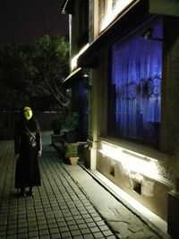 Full length of woman standing in city at night