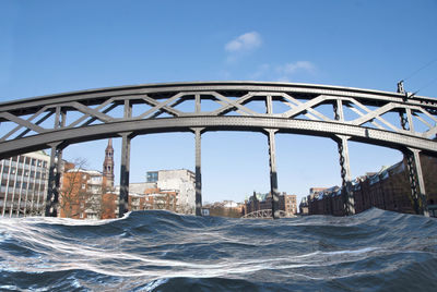 Arch bridge over sea against clear blue sky