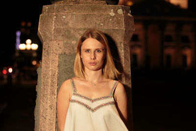 Portrait of beautiful young woman standing at night