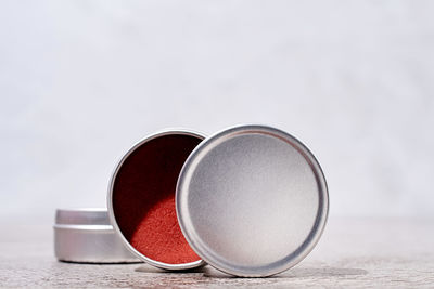 Colorful lip balms in round tin cases on light background with shadow overlay, mockup design, label