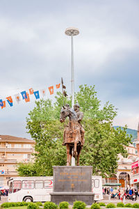 Statue against trees and sky in city