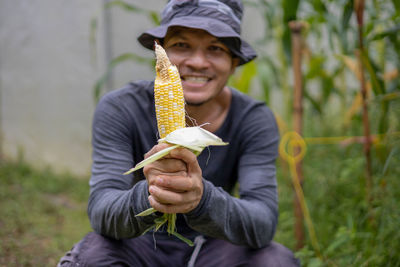 Cropped hand of woman holding corn