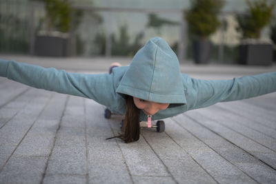 Full length of woman lying on footpath