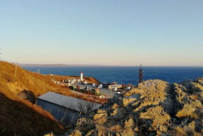 High angle view of buildings and sea against clear sky