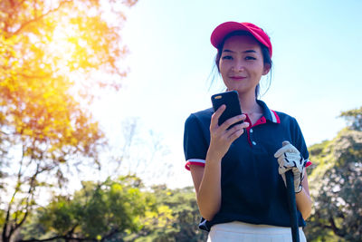 Full length of young woman using mobile phone