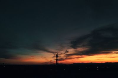 Silhouette electricity pylon against sky during sunset