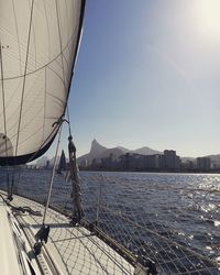 Sailboat sailing on sea against clear sky with skyline of rio de janeiro 