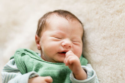 Close-up of cute baby boy sleeping on bed