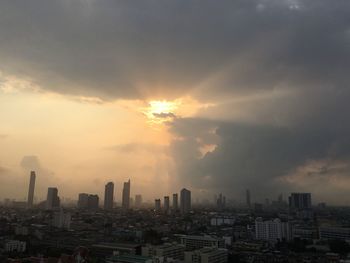 Modern buildings in city against sky during sunset