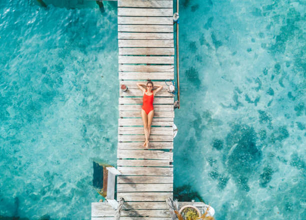water, blue, high angle view, staircase, day, nature, swimming pool, one person, adult, architecture, outdoors, wood, pier, men, leisure activity, lifestyles, directly above, turquoise colored, azure, sea, swimming, women, steps and staircases, relaxation, full length, ladder, standing, sunlight, vacation, trip, travel, built structure, summer, holiday, aqua