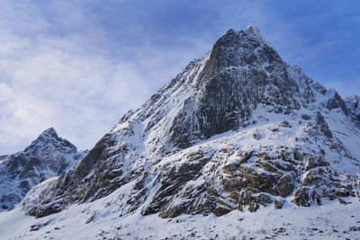 Low angle view of snowcapped mountain against sky