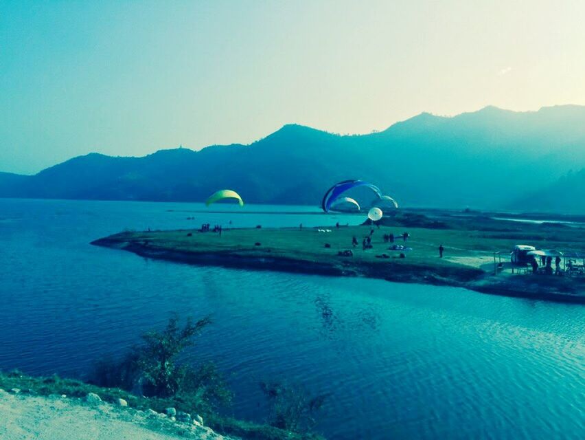 water, mountain, clear sky, tranquil scene, scenics, tranquility, sea, copy space, blue, beauty in nature, nature, mountain range, transportation, waterfront, idyllic, lake, nautical vessel, beach, outdoors, landscape