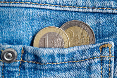 Close-up of coins in jeans pocket