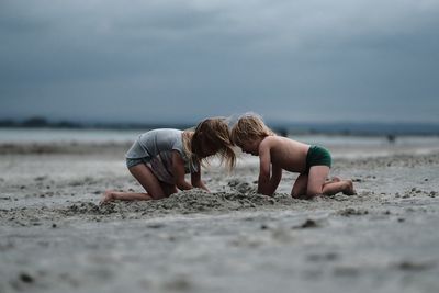 Friends on beach against sky