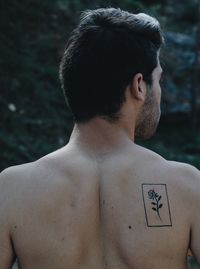 Side view of shirtless man standing outdoors