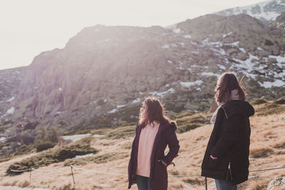 Rear view of women walking on mountain road