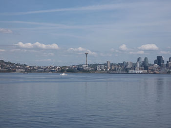 Sea by buildings against sky in city