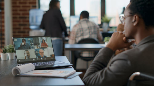 Businessman having video call through laptop at desk in office