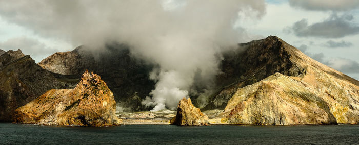 Panoramic view of sea and rocks against sky