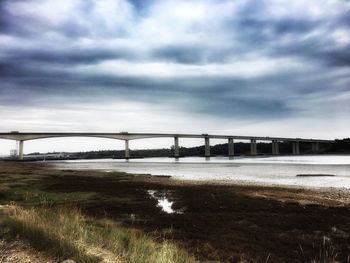 View of bridge over river against cloudy sky