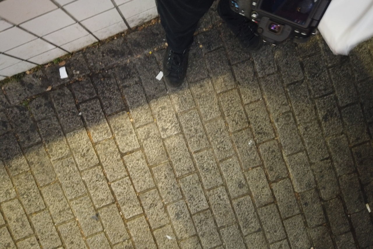 LOW SECTION OF PERSON STANDING ON SIDEWALK