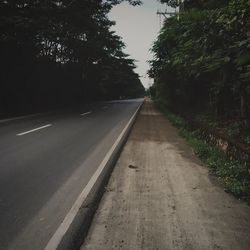 Road amidst trees against sky