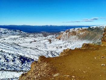 Scenic view of snow covered land against blue sky