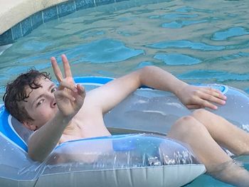 High angle portrait of shirtless boy swimming in pool