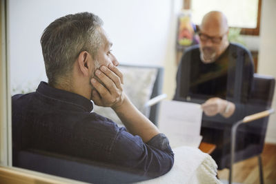 Thoughtful male patient sitting at therapy workshop