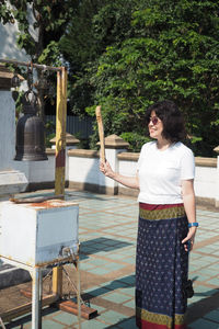 Full length of woman standing against trees