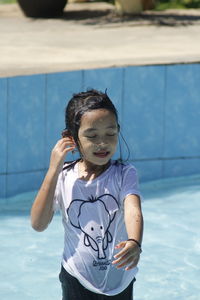 Portrait of cute girl standing in swimming pool