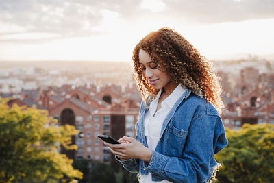 Midsection of man using mobile phone outdoors