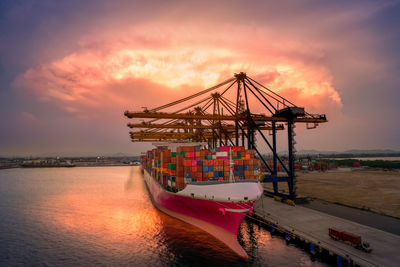 Crane loading cargo container to container ship in the international terminal logistic 