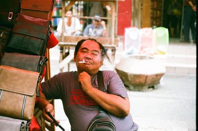 Portrait of smiling man sitting in city