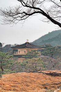 Built structure on field by buildings against sky