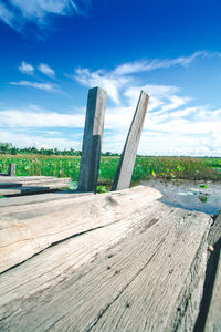 Wooden fence on field against sky