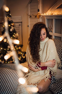 Young woman sitting in illuminated room