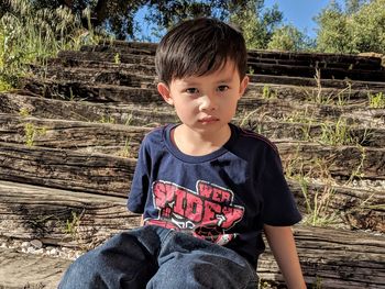 Portrait of cute boy sitting outdoors