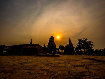 View of temple against building during sunset