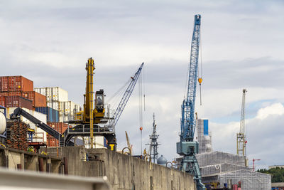 Cranes at construction site against sky